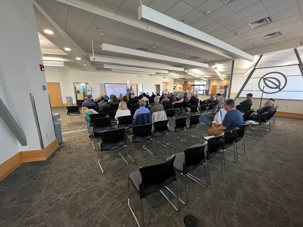 Photo from the Community Meeting, held on 02/24/2024. The photo shows approximately 50 people sitting together, reviewing the survey results for the project. 